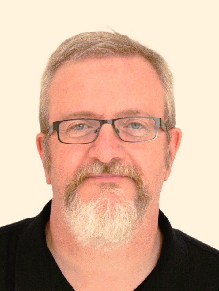 A photo of Ger Spillane. He is a white man wearing glasses with a beard.